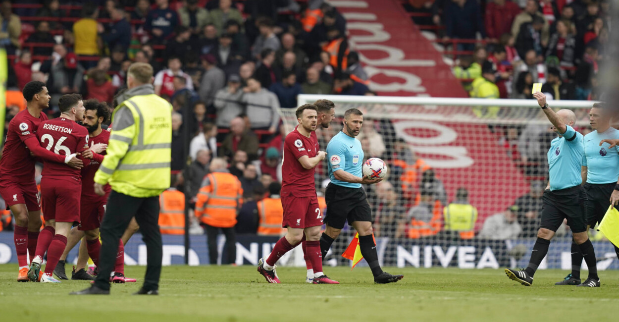 Robertson appears to be elbowed by the assistant referee during Liverpool vs Arsenal